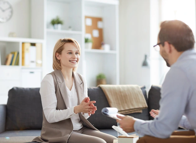 young adult female sitting with counselor and smiling optimistically