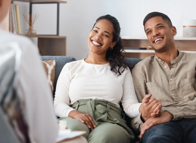happy smiling couple sitting in marriage counseling session